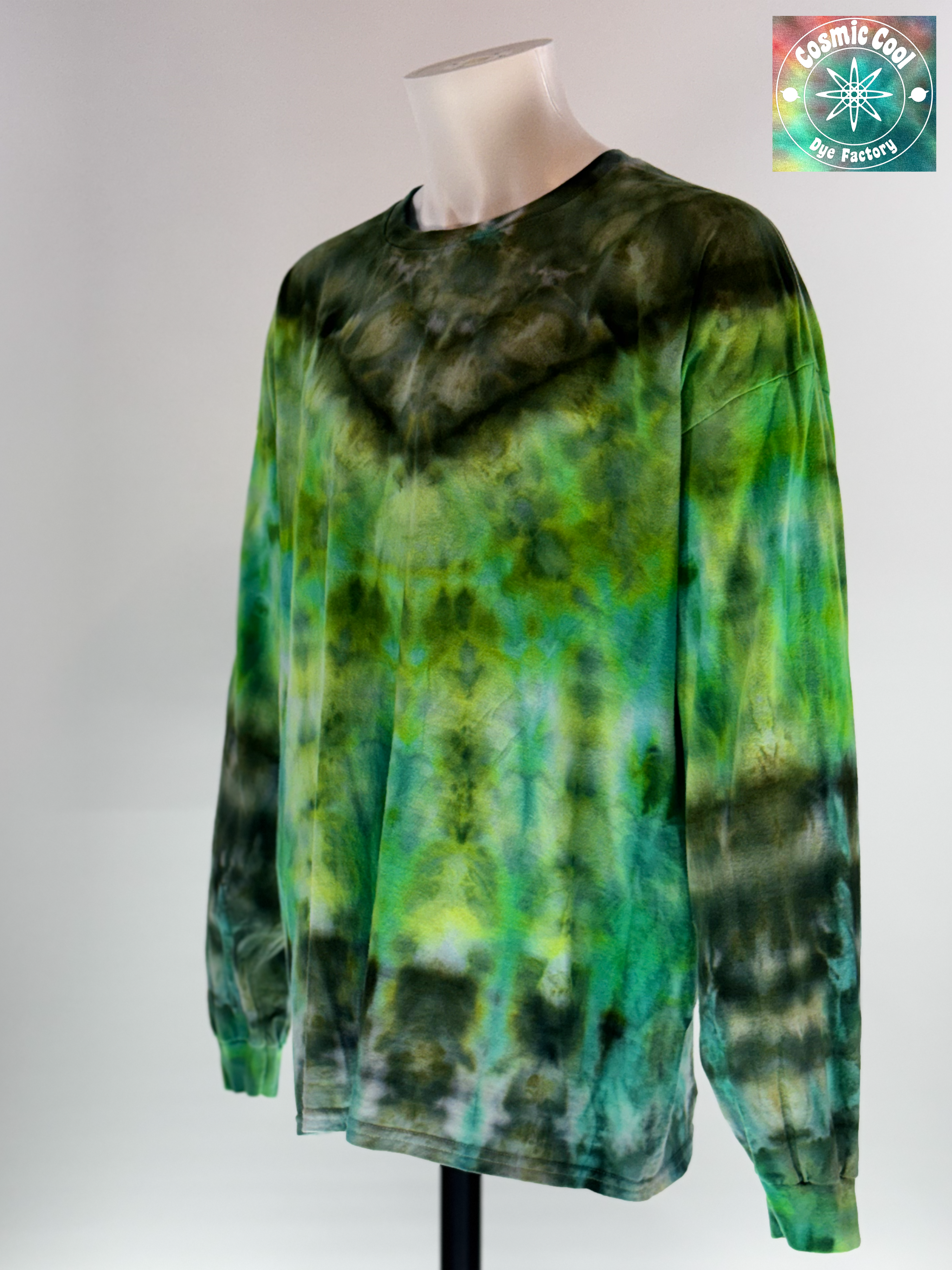 Angled Front view of a 3XL Long Sleeve Ice Dye T-shirt. The design features a dark green crystalline patterns radiating across a luminescent field of emerald green.