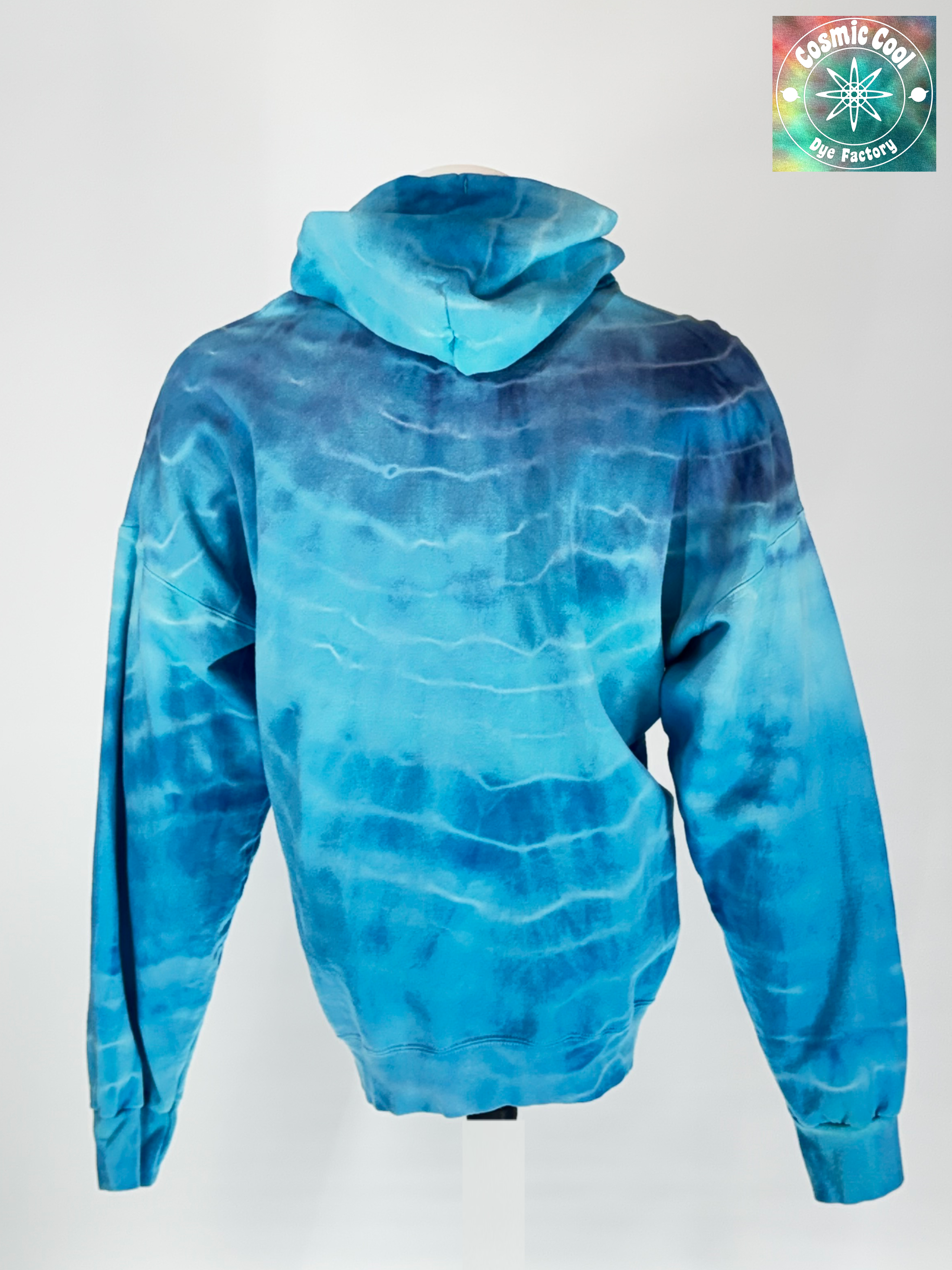 Back view of our 3XL Heavyweight Hoodie. "Glacial Fracture" mimics the tectonic shifting of an ancient ice shelf. We have allowed pigments to fracture a landscape of deep arctic blues and electric teals "shattered" by veins of brilliant, crystalline white.