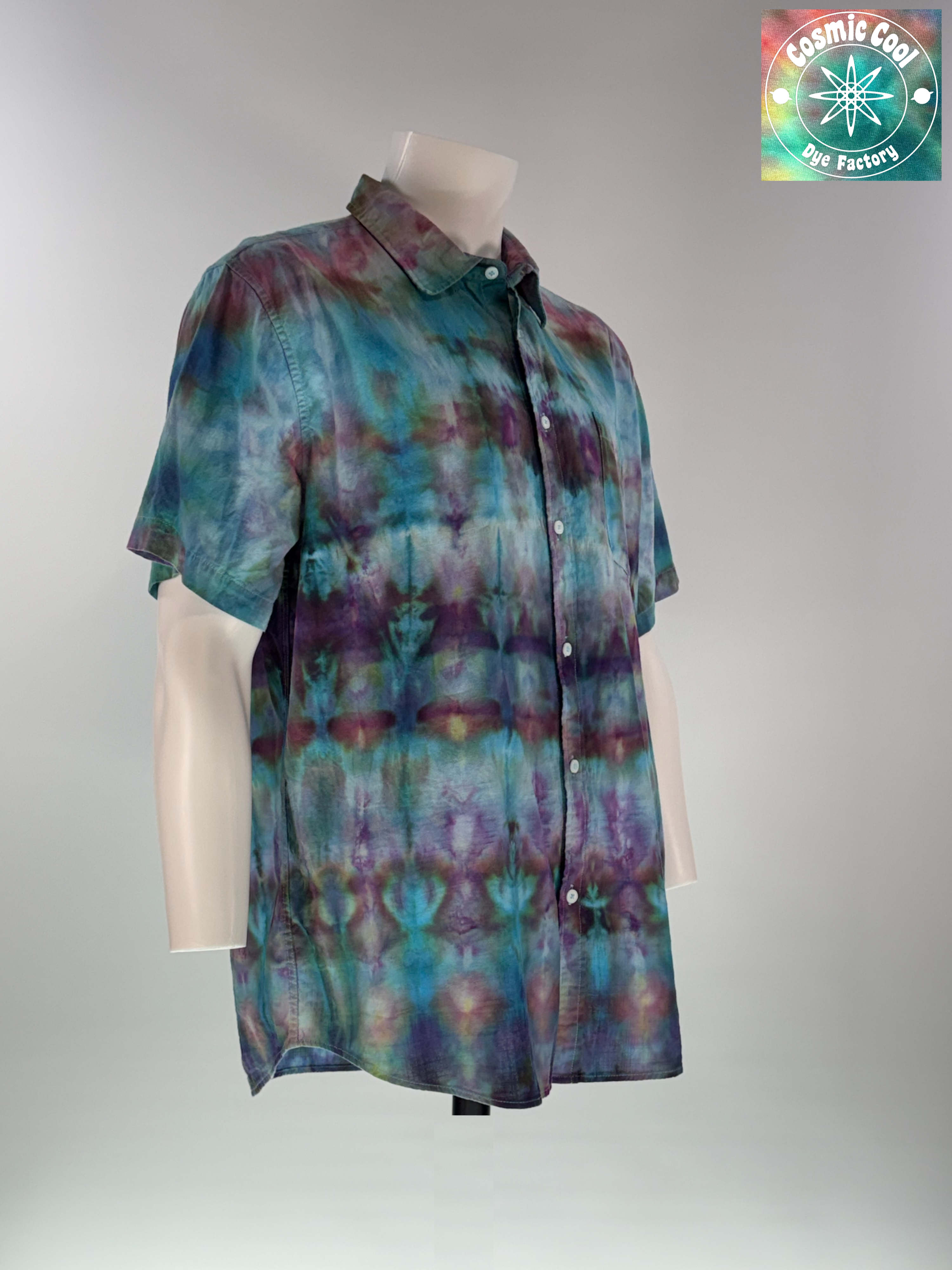 Angled 3/4 Front view of an extra-large Men's Ice Dye Cam Shirt. Our Nebula Drift short sleeve button down, collared shirt features a design saturated with amethysts and turquoise. Ice flow creating the watercolor like transitions across the fabric.