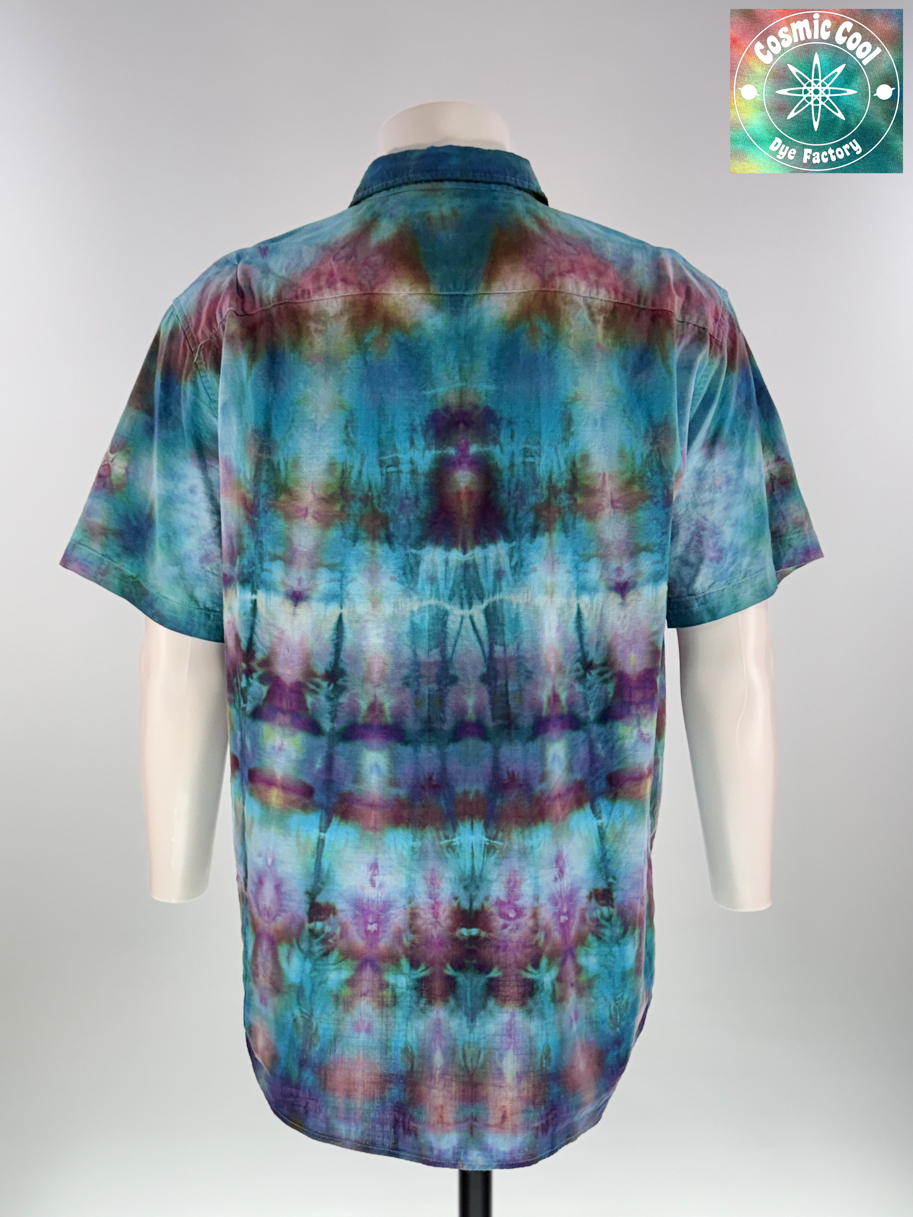 Back view of an extra-large Men's Ice Dye Cam Shirt. Our Nebula Drift short sleeve button down, collared shirt features a design saturated with amethysts and turquoise. Ice flow creating the watercolor like transitions across the fabric.