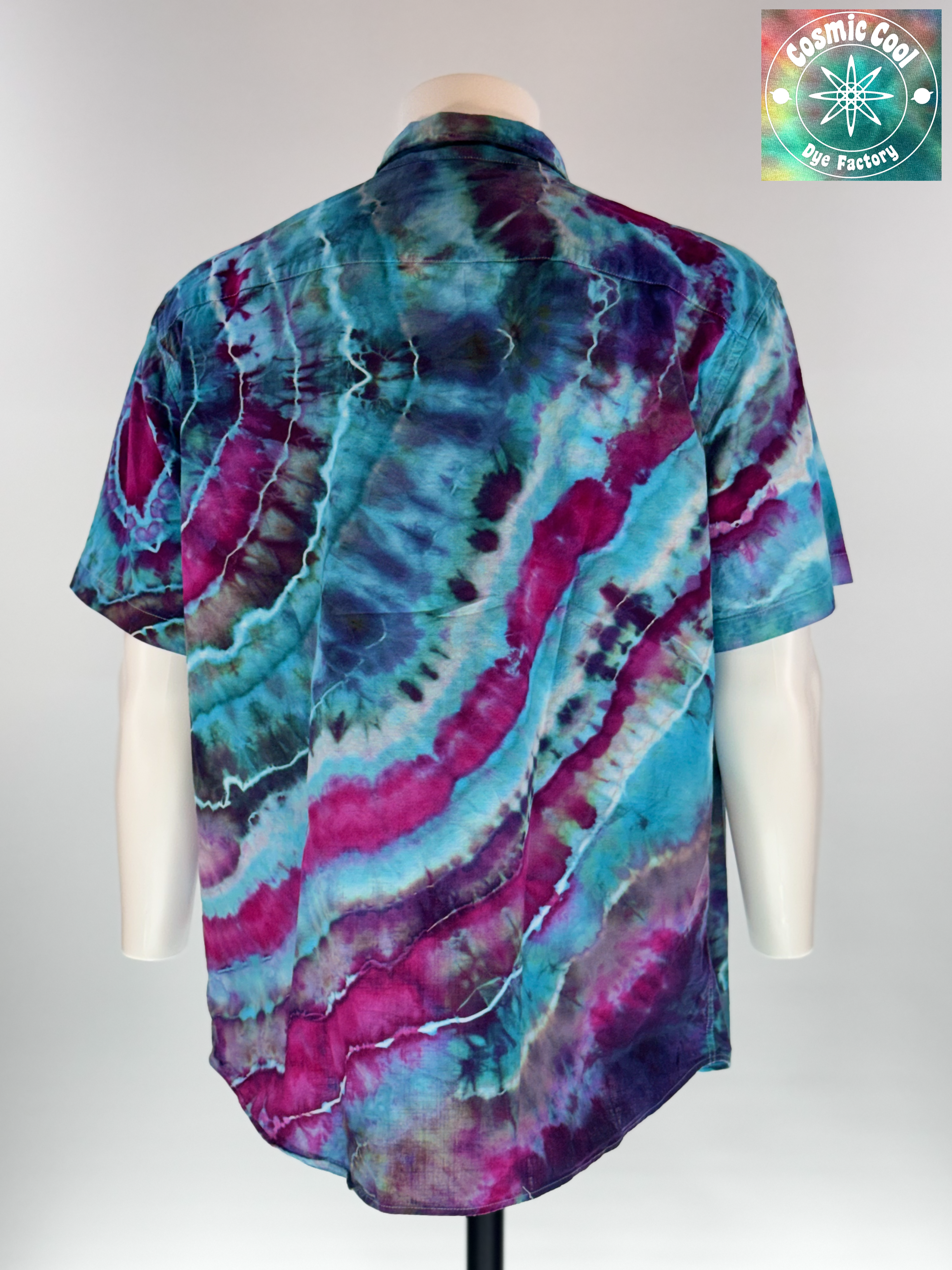 Back view of our Cosmic Camp Shirt. Geodesic tides mimics the rhythmic, mineral-like layering found in coastal geodes. The design features a cascading flow of deep amethyst and royal purple waves that wash over a vibrant turquoise and teal base.