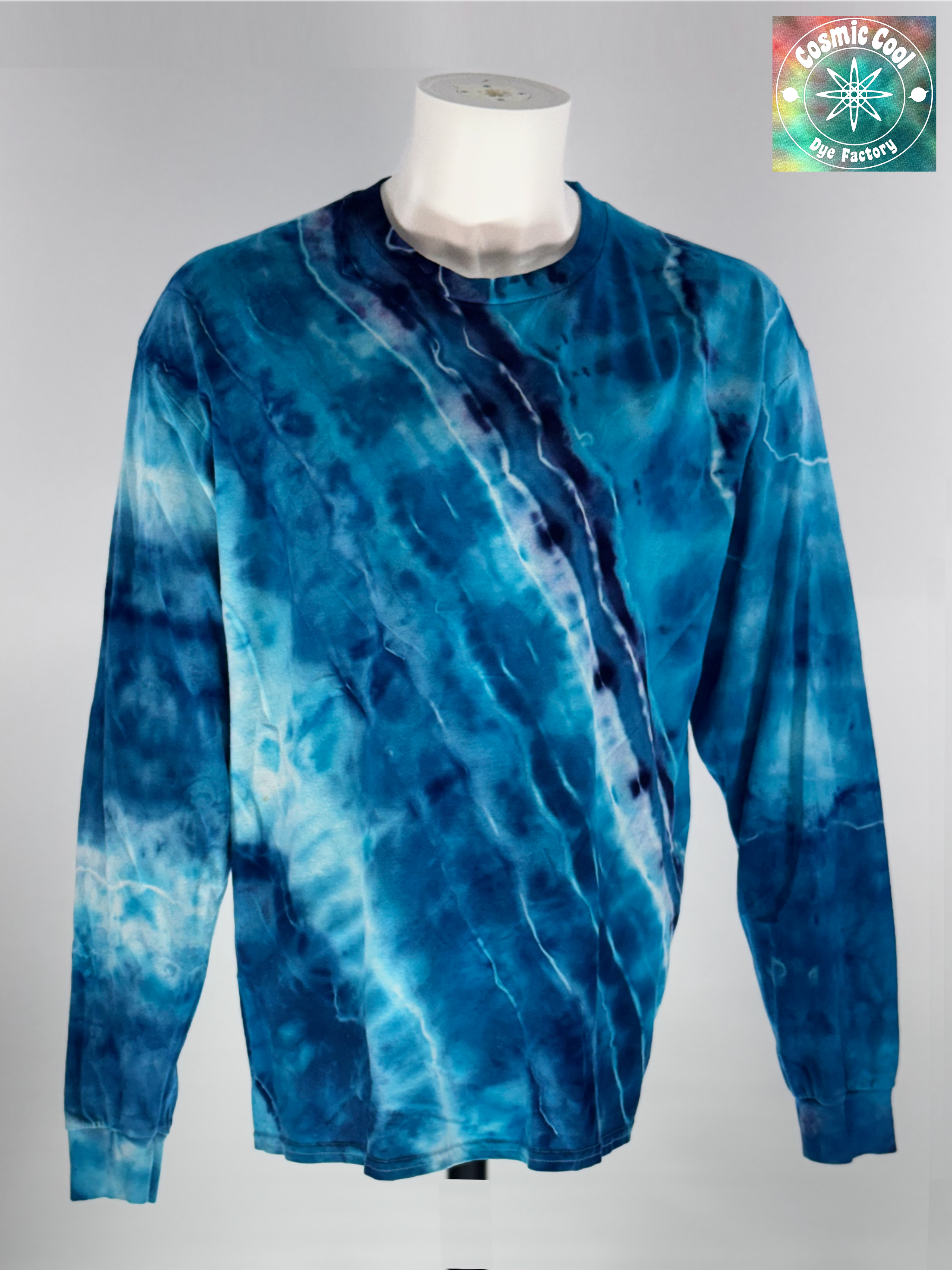Front view of XL Long Sleeve Ice Dyed Tee Shirt. Glacier Horizon is defined by a deep, diagonal "Tectonic Rift" of competing blues. Navy, Glacier, Cerulean, and Midnight blue that all leave their  Radiant "ice shelves" of turquoise and electric cerulean, creating a complex fracturing of color that mimics ancient, shifting ice. 