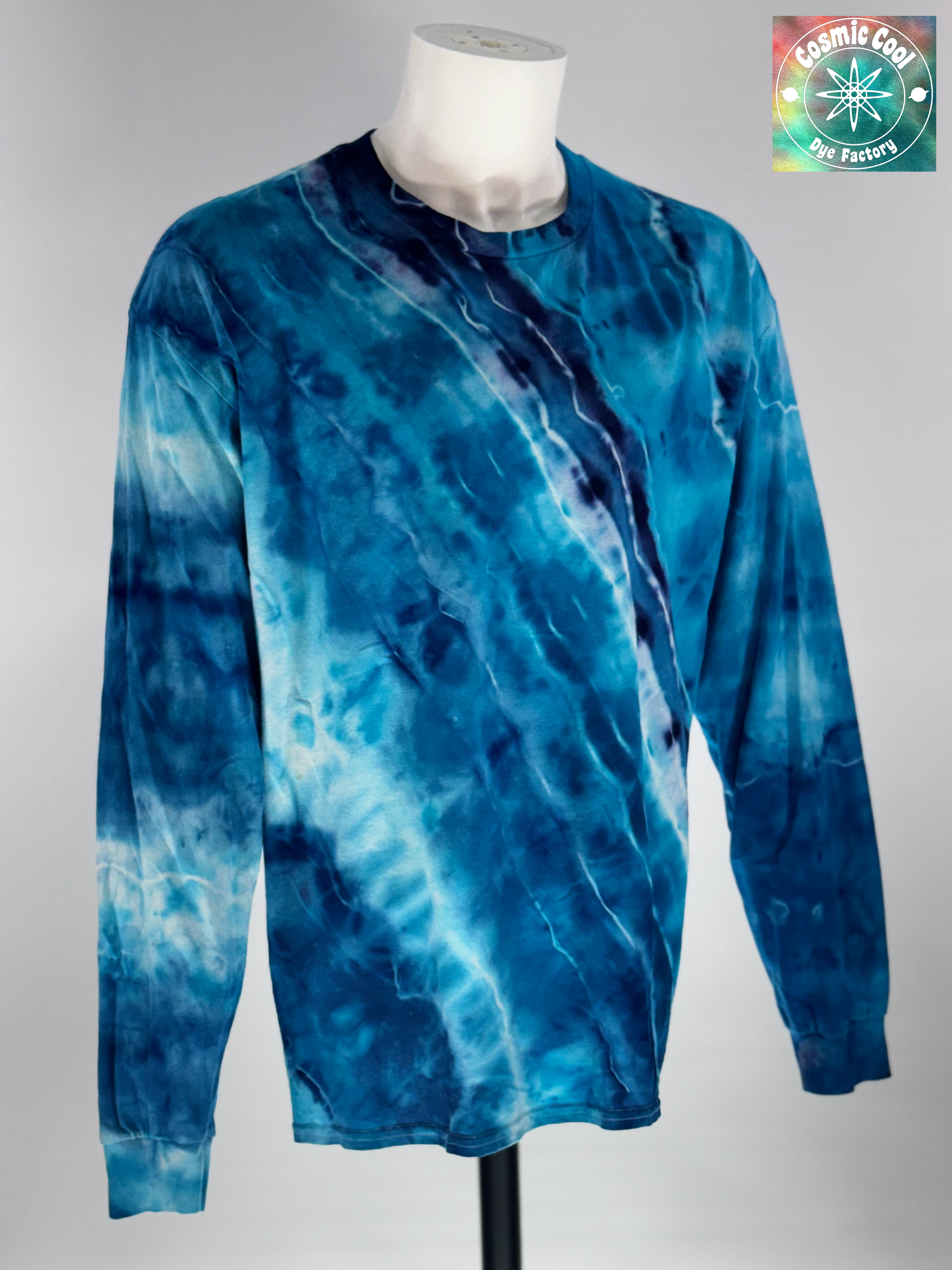 Front view of XL Long Sleeve Ice Dyed Tee Shirt. Glacier Horizon is defined by a deep, diagonal "Tectonic Rift" of competing blues. Navy, Glacier, Cerulean, and Midnight blue that all leave their  Radiant "ice shelves" of turquoise and electric cerulean, creating a complex fracturing of color that mimics ancient, shifting ice. 