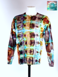 Front view of a Large Long Sleep Ice Dye Artisan Shirt. Phoenix Transformation features a complex, mirrored horizontal pattern. The design explores the elemental shift from deep, scorched umbers and charcoals into vibrant bursts of teal and ethereal light, capturing the very moment of a Phoenix's renewal.