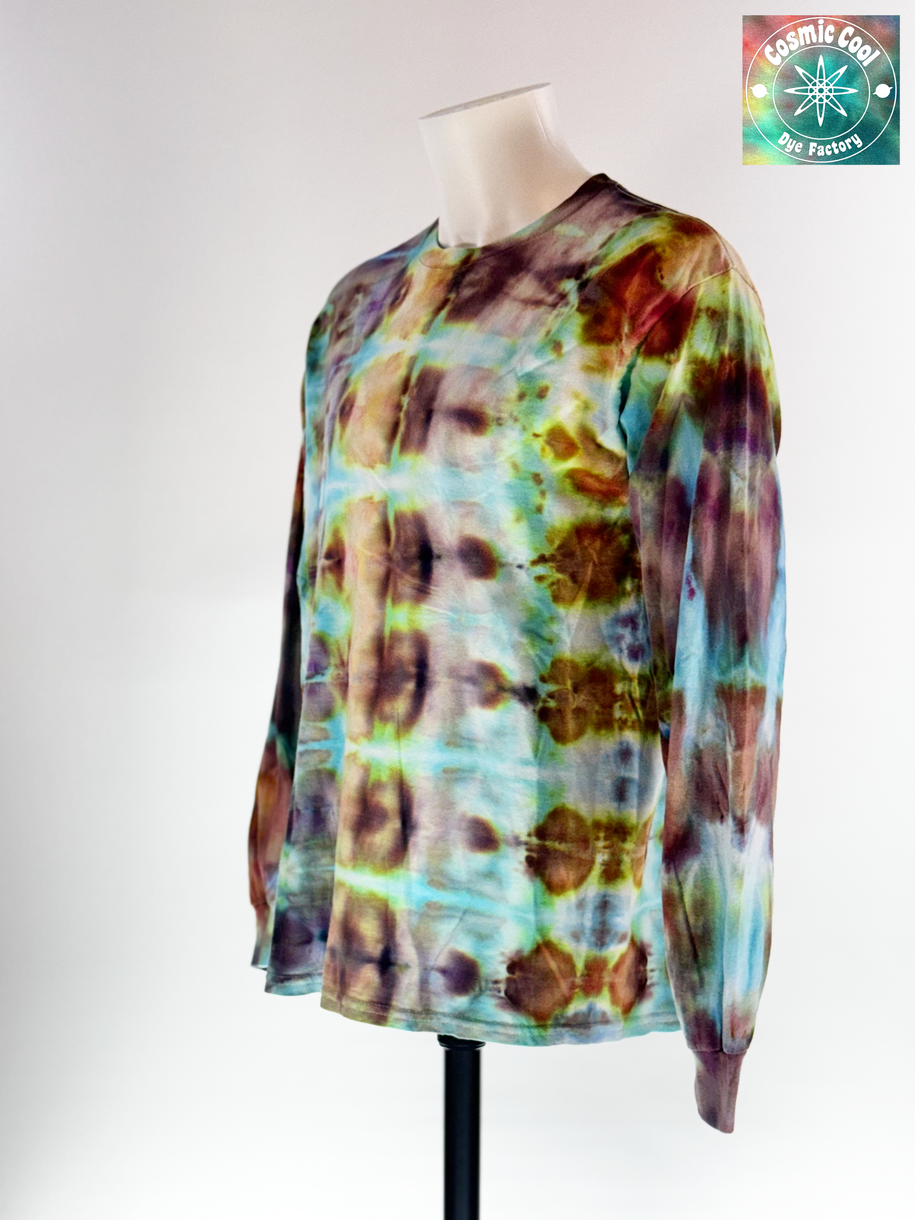 Angled 3/4 Front view of a Large Long Sleep Ice Dye Artisan Shirt. Phoenix Transformation features a complex, mirrored horizontal pattern. The design explores the elemental shift from deep, scorched umbers and charcoals into vibrant bursts of teal and ethereal light, capturing the very moment of a Phoenix's renewal.
