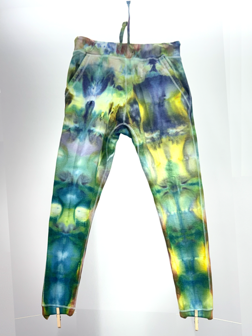 Tie-dye pants hanging on a line against a white background