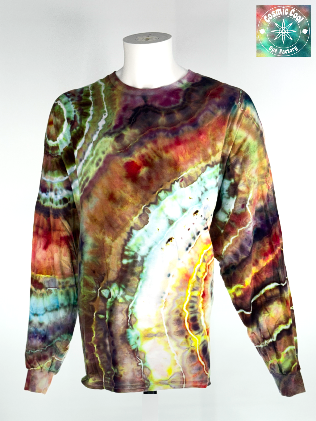 Video of a spinning 3XL long sleeve artisan ice dyed tee.The Desert Viper's Elixir features sharp, crystalline transitions between sun-bleached sand, deep ochre, and venomous greens. The pigments are driven to create a shifting, organic pattern that feels as if it were still in motion.